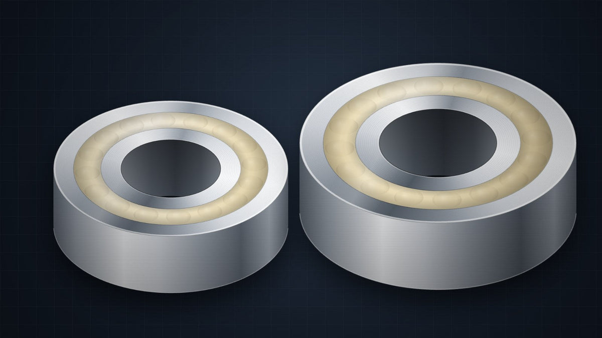 Two solid oil ball bearings, Standard chrome steel and Food Grade stainless, with the cream solid oil fill visible between the rings
